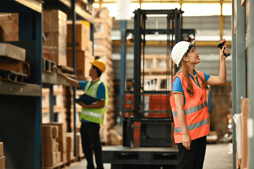 A warehouse worker using a handheld barcode scanner who would greatly benefit if the business he works for invested in more efficient wearable scanners 